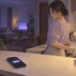 夜のキッチンで、夫のスマホに届いた通知を見つめる女性